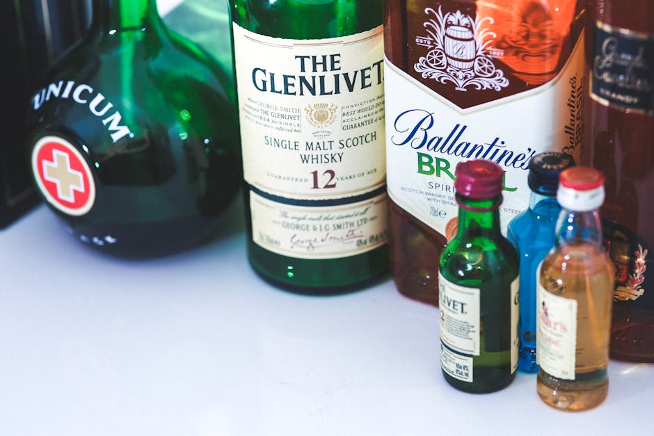 single malt whisky bottle collection, wooden table, moody lighting