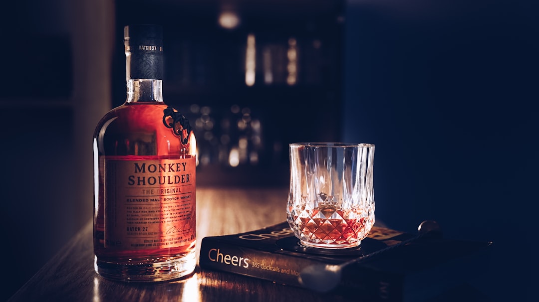 single malt whisky bottles lineup, amber whisky glass candlelight